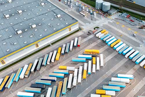 Trucks lined up at a warehouse representing outsourced logistics operations.