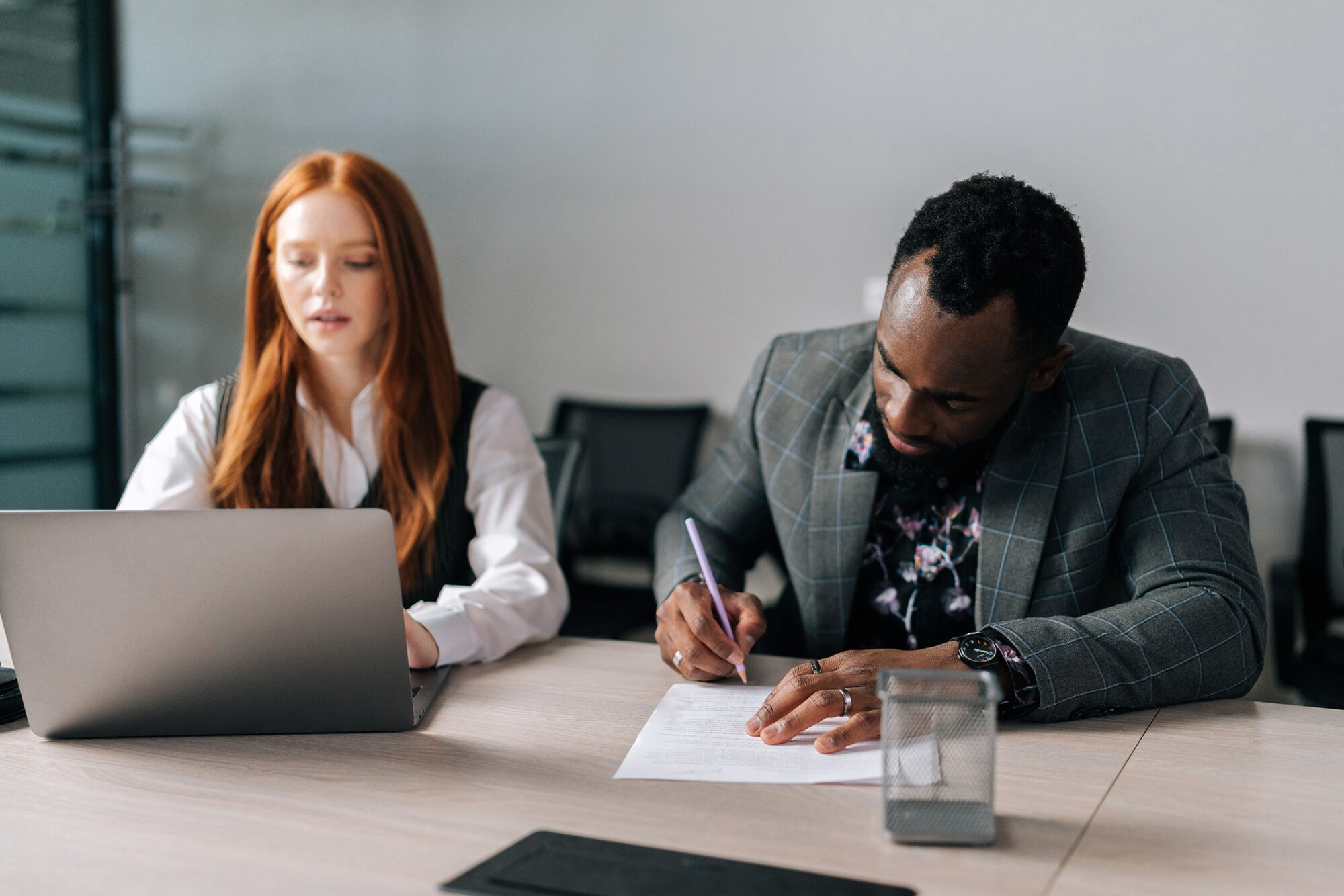 Business professional reviewing printed logistics RFP documents on desk with laptop and coffee, representing the detailed evaluation process for selecting 3PL partners